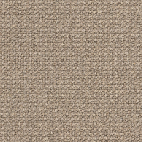 Close-up of Andros Berber Carpet in Oak, featuring a textured loop pile pattern with tightly woven fibers in tan and light brown shades for a durable finish.