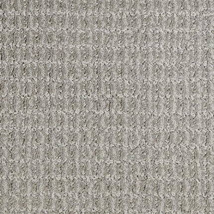Close-up of Yucatan Pet Friendly Carpet in Open Road, featuring a textured, light gray stain-resistant surface with a subtle, repeating square pattern for a soft and slightly raised look.