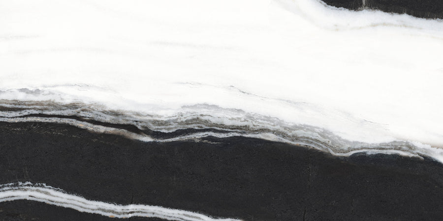 A close-up of a black stone surface with wavy white and gray veining patterns, resembling marble or onyx, creating a striking contrast and natural abstract design.