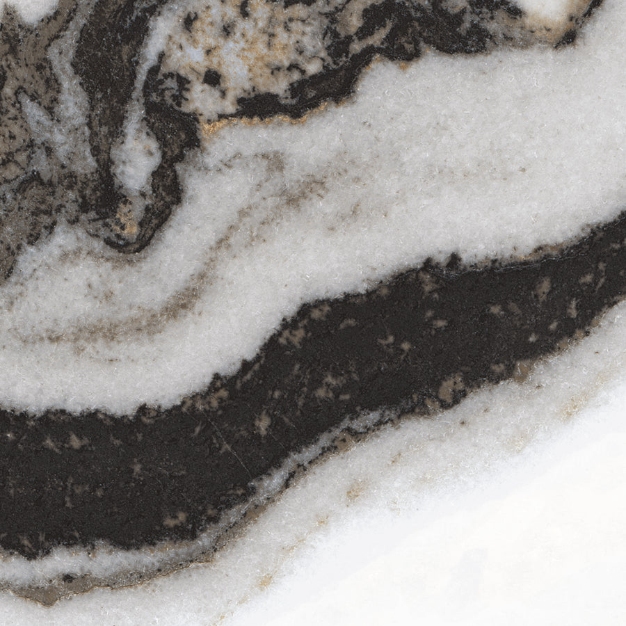 Close-up of a stone surface displaying wavy black, white, and beige mineral layers with a natural, marbled pattern.