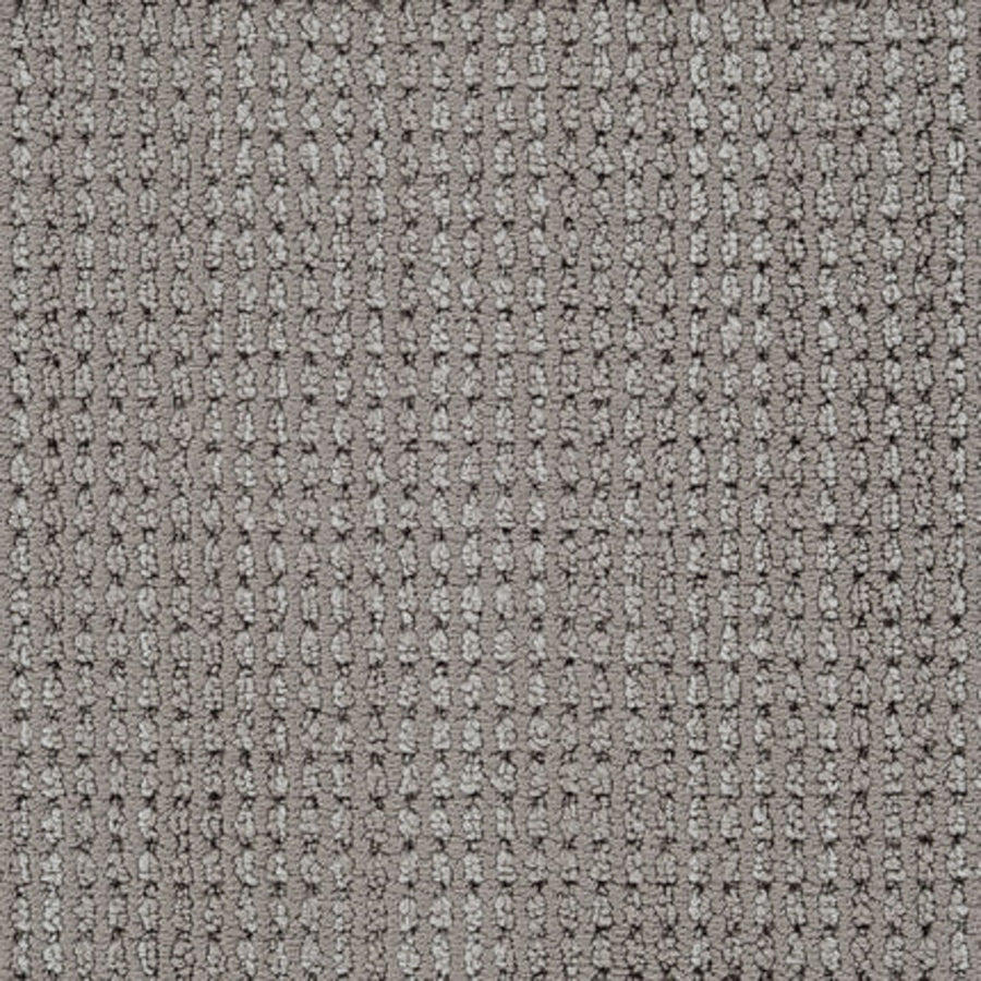 A close-up of Top Notch Berber Carpet in Otter shows its textured grid pattern with raised rectangular loops, subtle color variations, and a stylish design that’s stain resistant—an ideal choice for premium flooring.