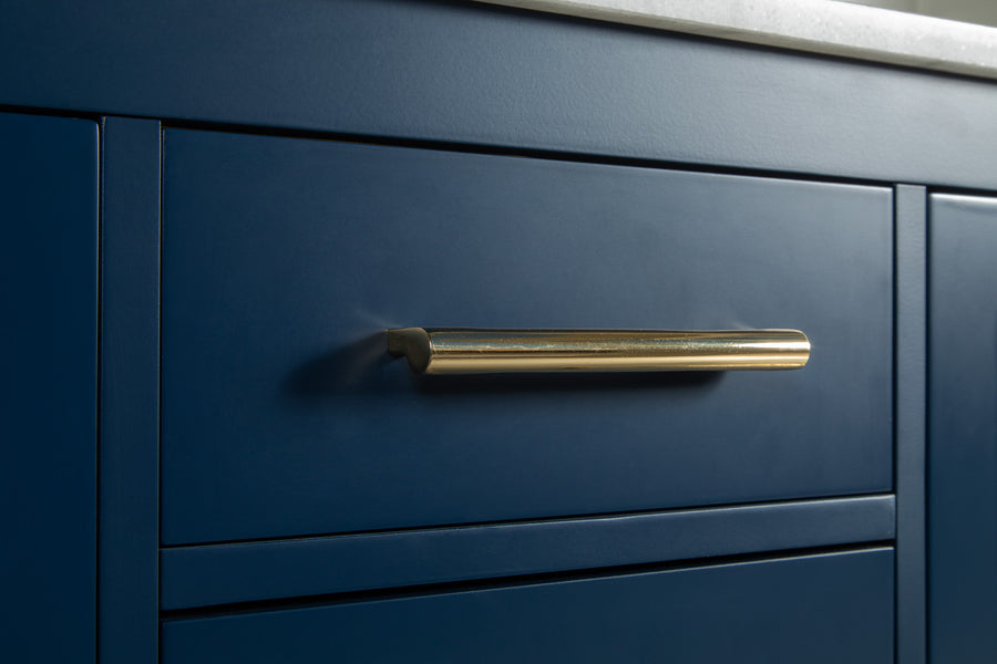 Close-up of a matte blue cabinet drawer with a long, horizontal gold handle beneath a white countertop.