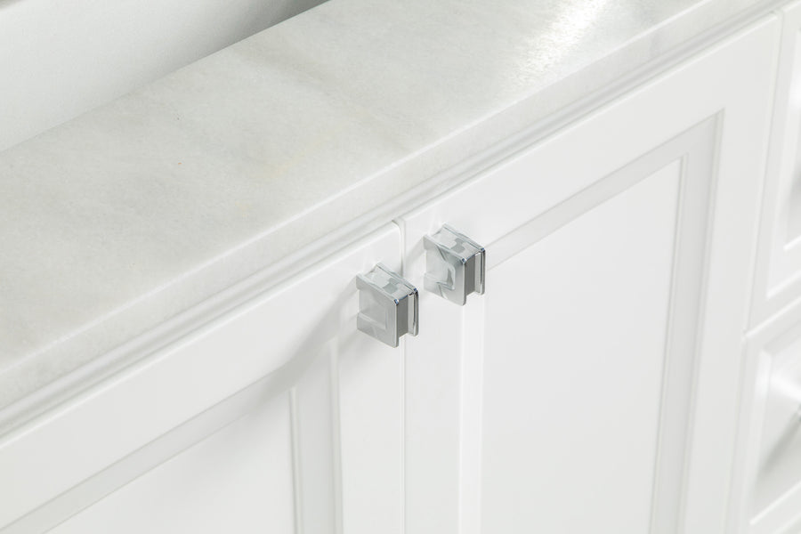 A close-up of a white cabinet with two doors secured by a clear, plastic child safety lock attached to the handles.