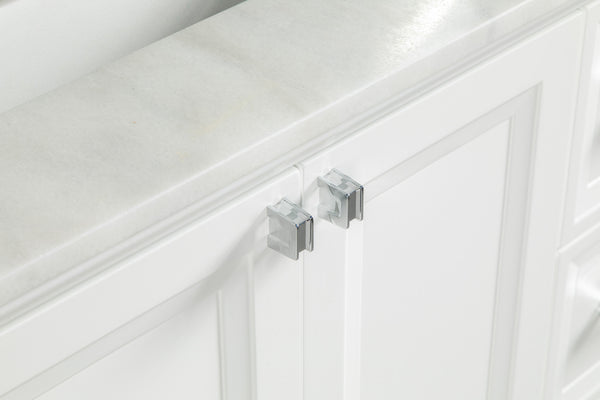 A close-up of a white cabinet with two doors secured by a clear, plastic child safety lock attached to the handles.