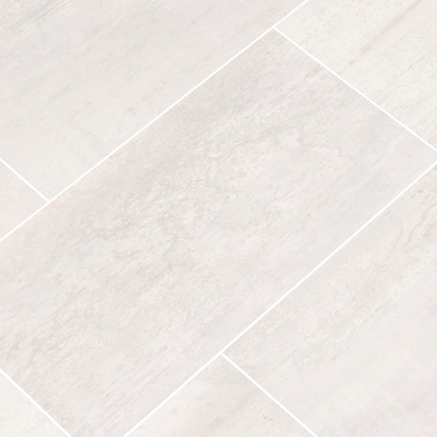 Close-up of Oxide 12x24 Rectified Ceramic Tile in light gray, featuring a subtle stone texture and offset pattern. Thin white grout lines enhance its modern style—perfect for backsplashes or pairing with countertops.