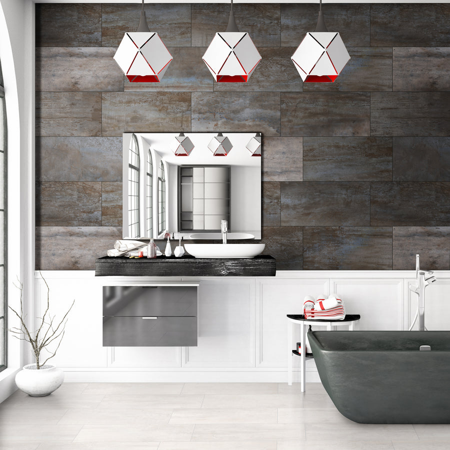 Modern bathroom with dark, textured wall tiles, a floating vanity, a large mirror, and three geometric pendant lights. A freestanding tub and minimal decor, including a vase with branches, complete the sleek design.