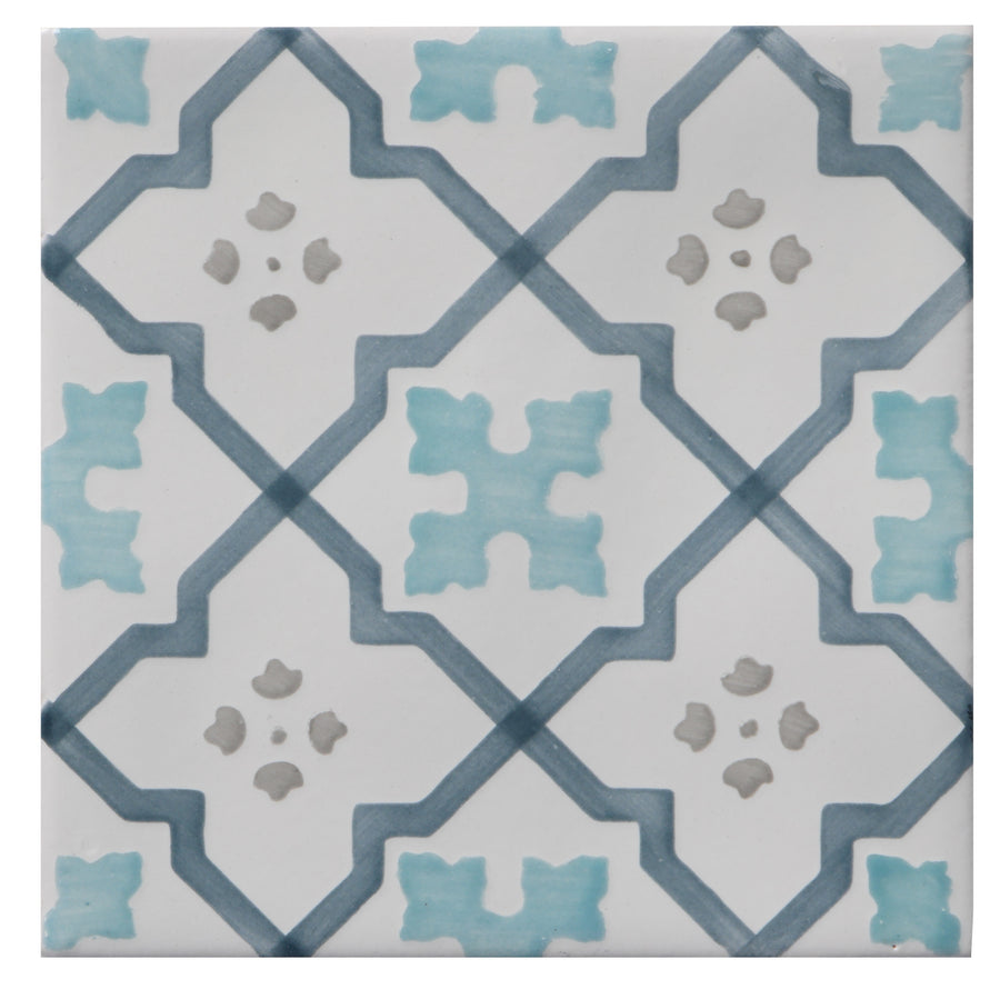 The Zephyr 4x4 Talisman Deco Ceramic Tile features a white background with blue diamond and stylized blue-gray floral motifs, inspired by Mediterranean craftsmanship.