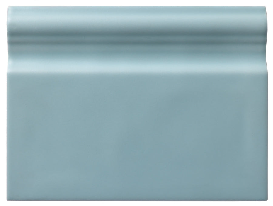 The Zephyr 6x8 Ceramic Baseboard is a rectangular, glossy light blue tile with a raised rounded top edge. Its smooth, reflective finish brings handcrafted luxury, perfect for special-order collections or Mediterranean baseboard accents.