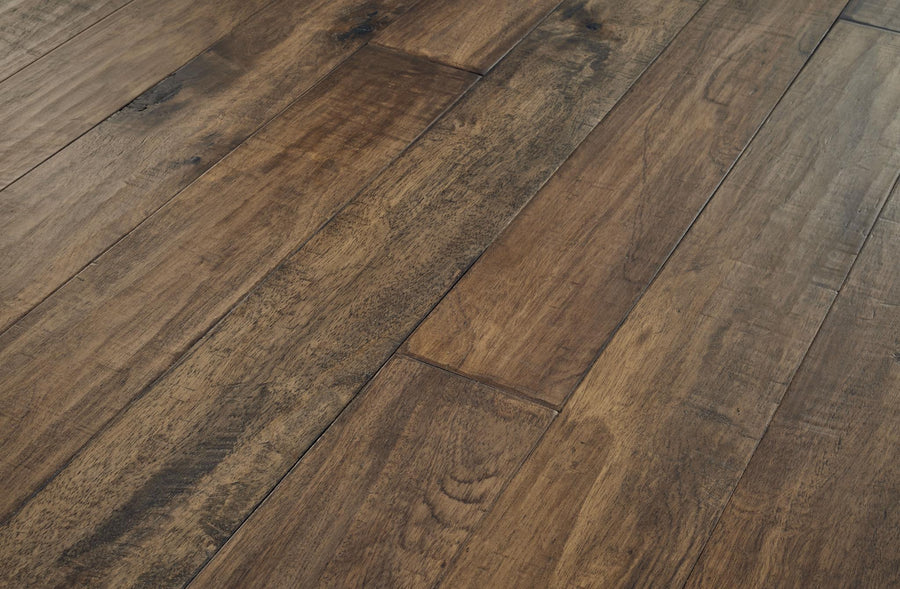 Close-up view of natural wooden floorboards with a rich brown finish, visible grain patterns, and subtle variations in color and texture.