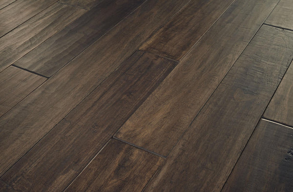 Close-up view of dark brown wooden floorboards with a smooth finish and visible wood grain patterns, showing a natural and rustic appearance.