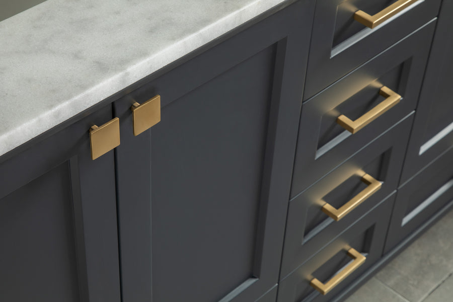 Dark gray kitchen cabinets with a white marble countertop, featuring modern gold square and rectangular handles on the cabinet doors and drawers.