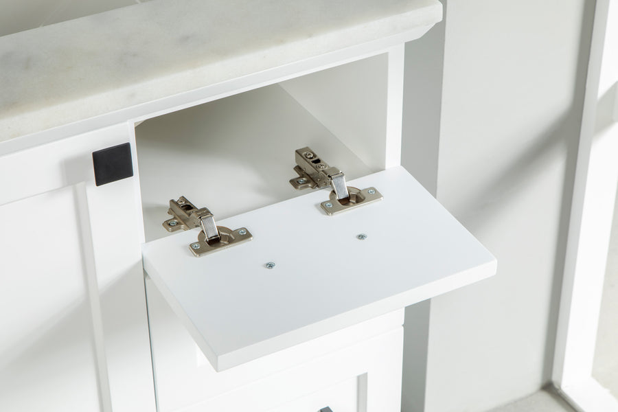 A close-up of a white cabinet with a marble top and an open drop-down door, showing two silver metal hinges attached inside. Sunlight streams onto the cabinet from the right.