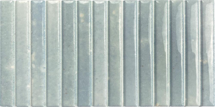 Parallel 4.5 x 9.1 Glazed Porcelain Tile features a rectangular, vertically fluted design in a soft light blue-green hue, accented by subtle variations and slight surface speckles.