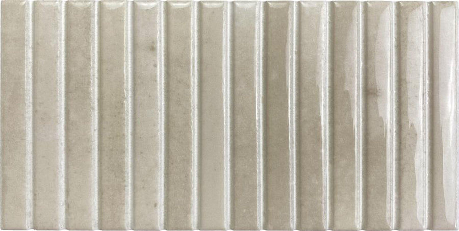 Parallel 4.5 x 9.1 Glazed Porcelain Tile features a rectangular shape, fluted vertical ridges, and a glossy light beige surface with subtle color and texture variations.