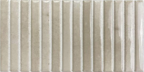 Parallel 4.5 x 9.1 Glazed Porcelain Tile features a rectangular shape, fluted vertical ridges, and a glossy light beige surface with subtle color and texture variations.