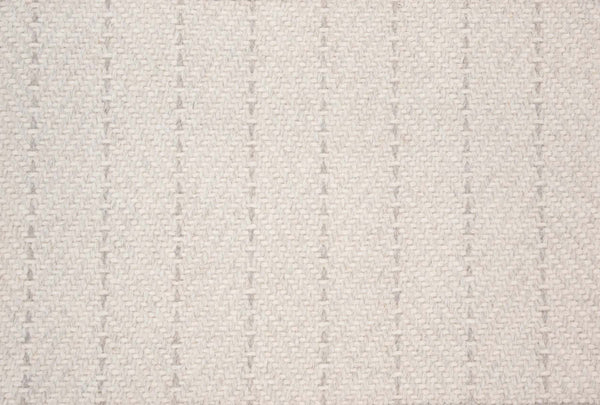Close-up of Angola Berber Carpet in Parchment—a beige fabric with a textured woven pattern and subtle vertical dotted lines. The soft, minimalist, neutral design makes it ideal for contemporary interiors.