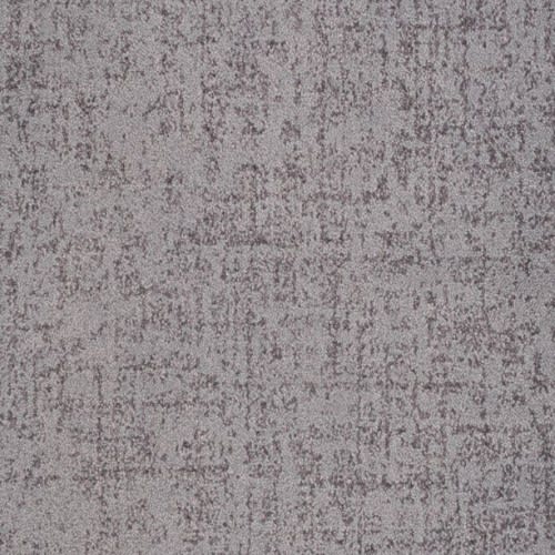 Hollywood Nights On Trend Carpet in Passion features a gray textured surface with irregular, speckled patterns reminiscent of concrete, offering modern style and premium durability—perfect for luxurious flooring.