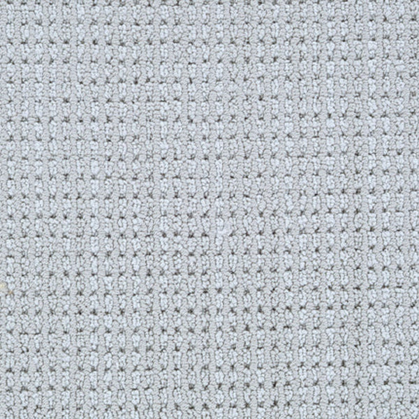 Close-up of Top Notch Berber Carpet in Pavement, featuring a light gray hue with a small square waffle pattern. This premium flooring is soft, evenly woven, and offers outstanding stain resistance.