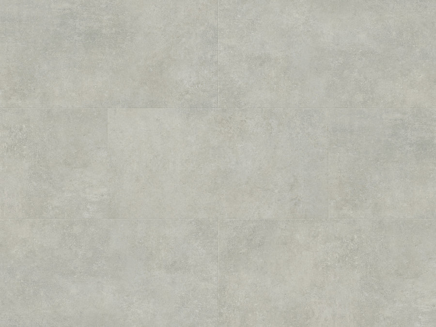 A close-up of Art Select Click 18" x 36" Vinyl Plank in Pavimento Bianco shows a light gray, textured surface with subtle color variations and faint joint lines, offering durable flooring that replicates modern large-format stone tile.