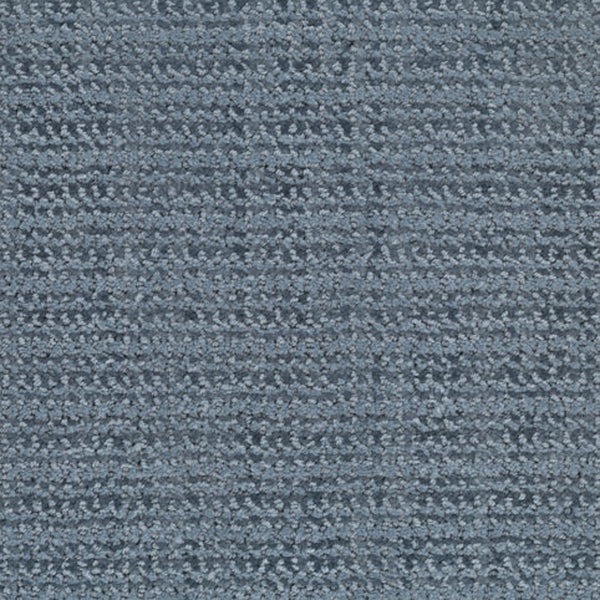 A close-up view of the Beguiling Berber Carpet in Peaceful, featuring a textured surface and a subtle grid pattern formed by raised and lower rows, showcases this luxurious flooring option.