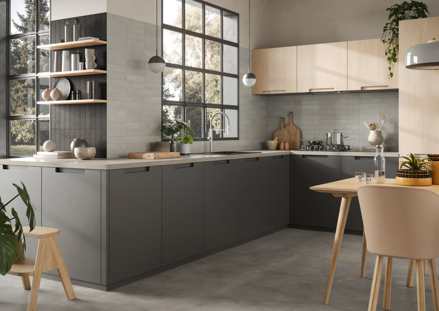 Modern kitchen with gray lower cabinets, light wood upper cabinets, open shelves, and large black-framed windows. A wooden table with chairs and potted plants are in the foreground, with natural light filling the room.