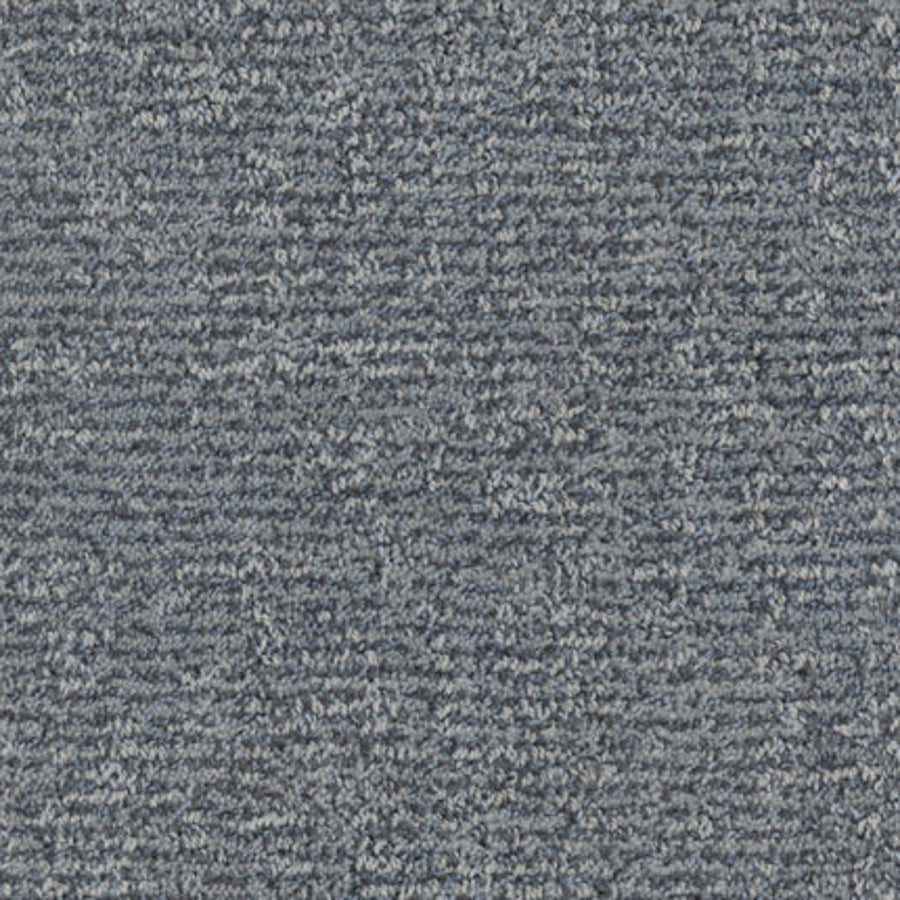 Close-up of Balance Family Friendly Carpet in Placid, featuring a blue-gray textured surface with subtle linear patterns. Soft, densely woven fibers provide a uniform yet varied look, while ensuring durability and stain resistance.