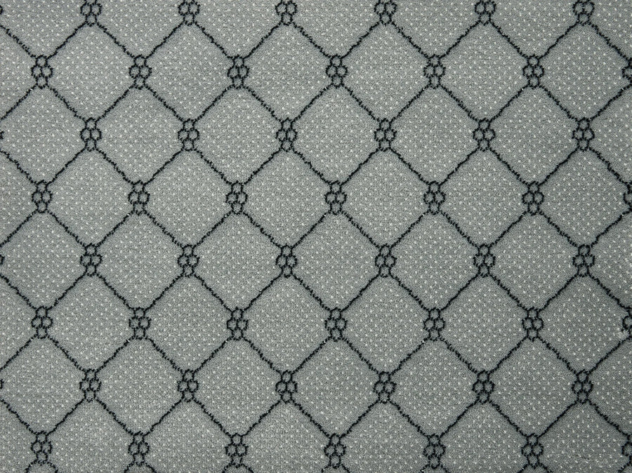 Lake Boden Berber Carpet in Platinum features a gray base with repeating diamond lattice patterns of black lines and clustered dots, creating a geometric, textured look ideal for durable flooring in any modern home.