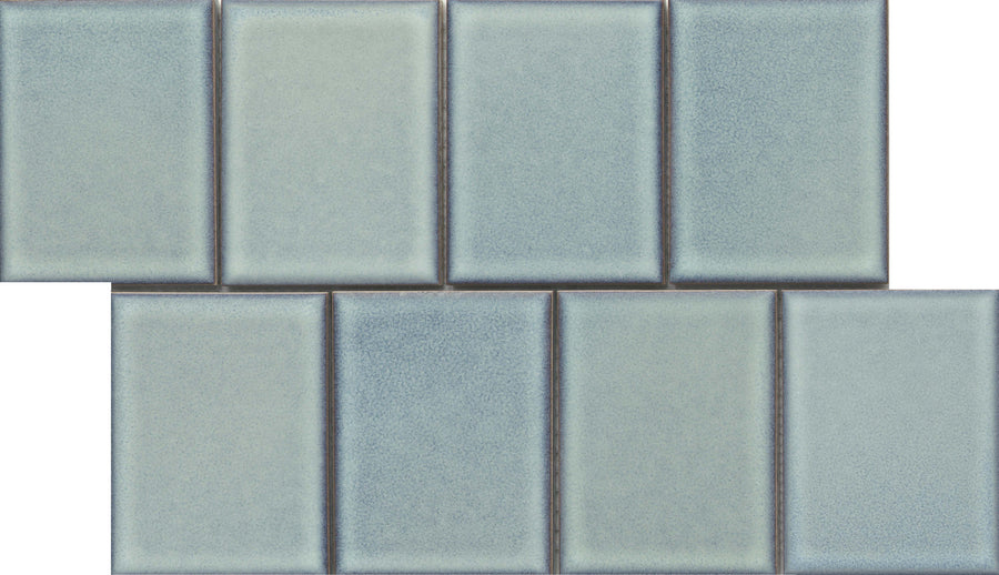 Eight Marco and Polo 4x5 Glossy Porcelain Tiles in Polo Horizon are arranged in two offset rows, resembling a brick pattern. The tiles have a designer look with a slight gradient, soft edges, and subtle surface texture.