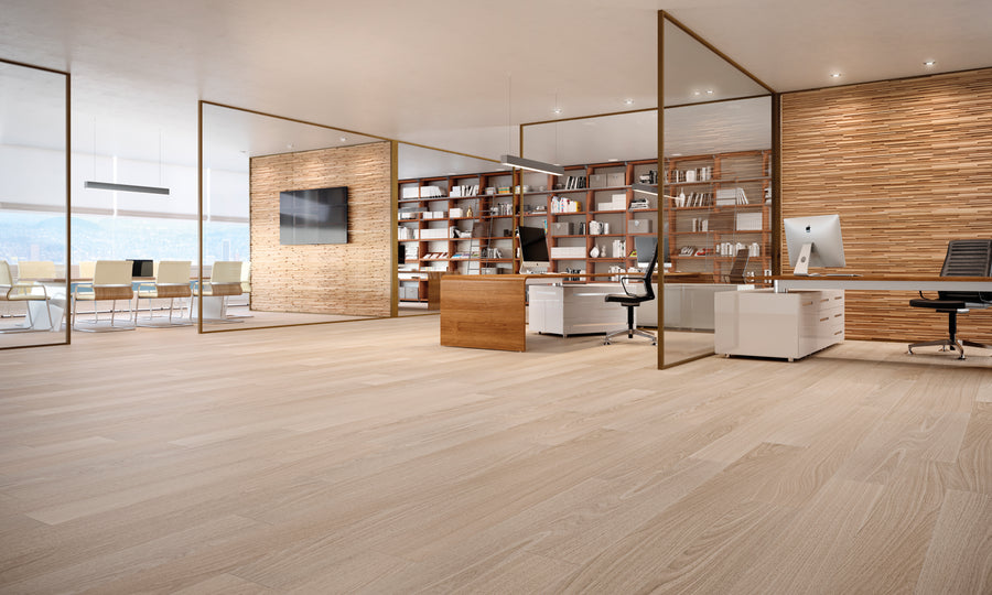Modern office with wooden floors, glass walls, bookshelves, a large desk, computer, chair, and a wall-mounted TV. In the background, there is a conference room with a long table and chairs. The space is spacious and bright.