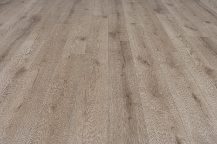 Concorde 7.2" Luxury Vinyl Plank showcases a light brown wood-look finish with a natural grain pattern and seamless design, viewed from a low angle to emphasize its elegant texture and premium appearance.
