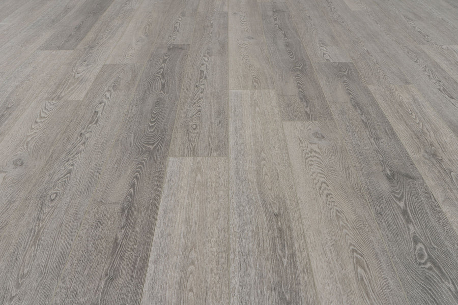 A close-up of Concorde 7.2" Luxury Vinyl Plank flooring, featuring planks in varied grey and brown shades with natural wood grain patterns and a realistic wood-look finish.