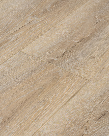 Close-up of Moda Living II 7.15" Luxury Vinyl Plank flooring in light brown, featuring visible wood grain texture, subtle color variations, and a staggered plank pattern.