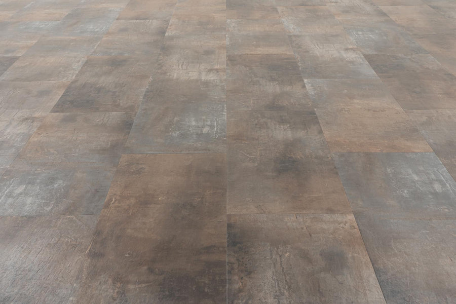 A close-up of Stonescape Luxury Vinyl Plank shows large, rectangular brown and gray tiles in a grid, offering stone-inspired looks with subtle color and finish variations for a durable flooring option.