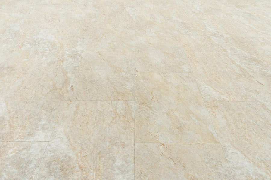 Close-up of Stonescape Luxury Vinyl Plank flooring in beige and light brown, featuring subtle natural stone patterns and textures. The durable rectangular planks are arranged in a staggered pattern for a realistic look.