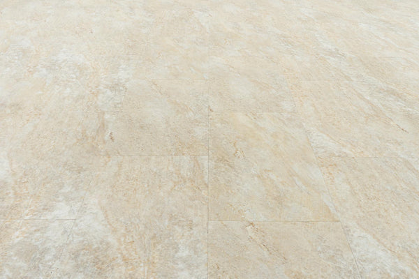 Close-up of Stonescape Luxury Vinyl Plank flooring in beige and light brown, featuring subtle natural stone patterns and textures. The durable rectangular planks are arranged in a staggered pattern for a realistic look.