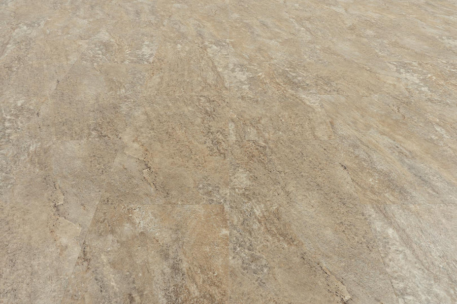 A close-up view of a textured, light brown floor showcases Stonescape 12x24 Luxury Vinyl Plank, featuring subtle color variations and natural-looking stone aesthetics.