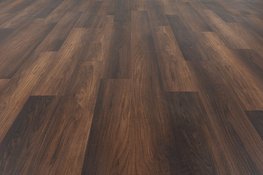 A close-up of Uptown Chic 7.15" Luxury Vinyl Plank flooring, featuring dark and medium brown planks in a staggered pattern that showcases realistic wood grain and texture.