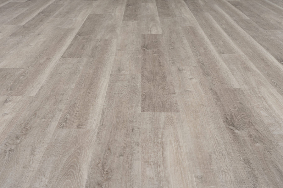 Uptown Chic 7.15" Luxury Vinyl Plank features light brown wood-look flooring with natural grain patterns and subtle color variations, shown from above as it extends into the distance.
