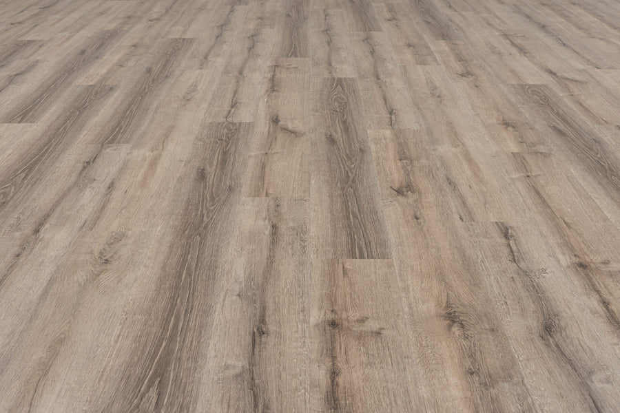 The Uptown Chic 7.15" Luxury Vinyl Plank features a light brown wood look with natural grain patterns and knots, smooth texture, and varied tan and brown tones that create a spacious, elegant appearance.