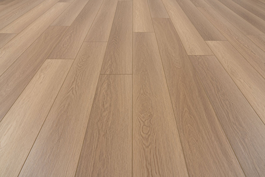 Uptown Chic 7.15" Luxury Vinyl Plank features wide, light brown planks arranged in a staggered pattern with a smooth finish and visible wood grain texture running lengthwise.