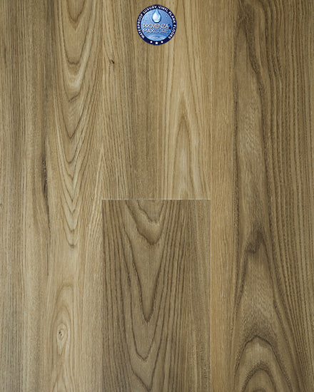 A close-up of Uptown Chic 7.15" Luxury Vinyl Plank flooring in light brown with natural grain patterns. A small round blue sticker with a logo is positioned near the top center of the image.