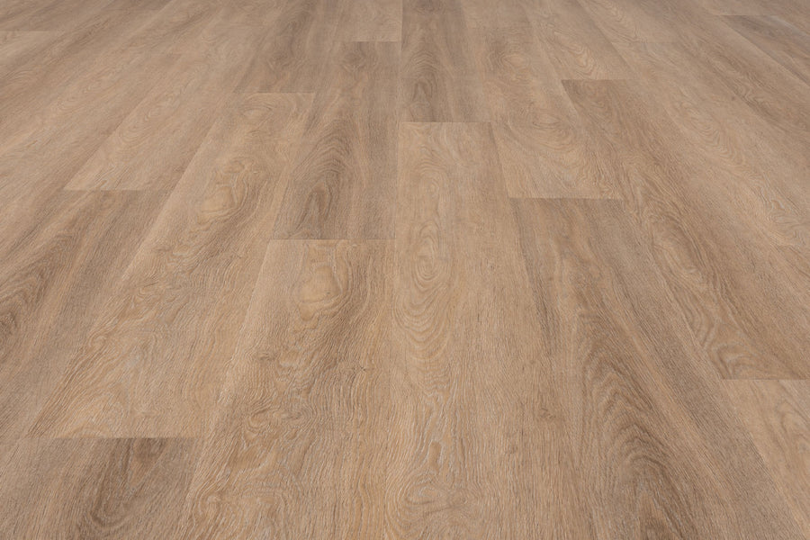 The Uptown Chic 7.15" Luxury Vinyl Plank features a light brown, natural grain look with wide planks in a staggered layout. Its smooth, clean surface creates a warm and inviting atmosphere for any space.