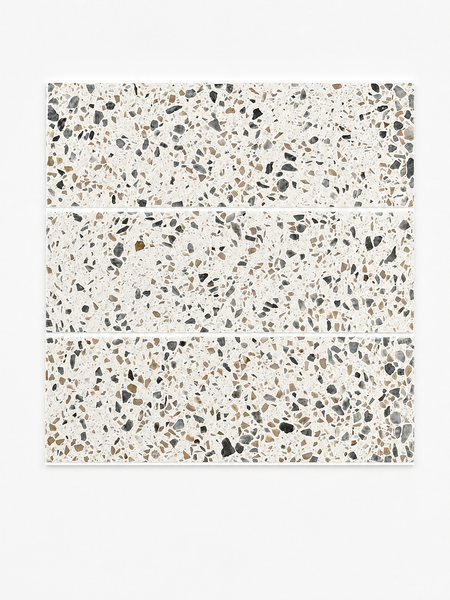 Three rectangular Revive Terazzo 4x12 Natural Stone tiles in the color Pave, featuring a white base with an array of black, gray, and brown stone chips, are arranged horizontally against a plain white background.