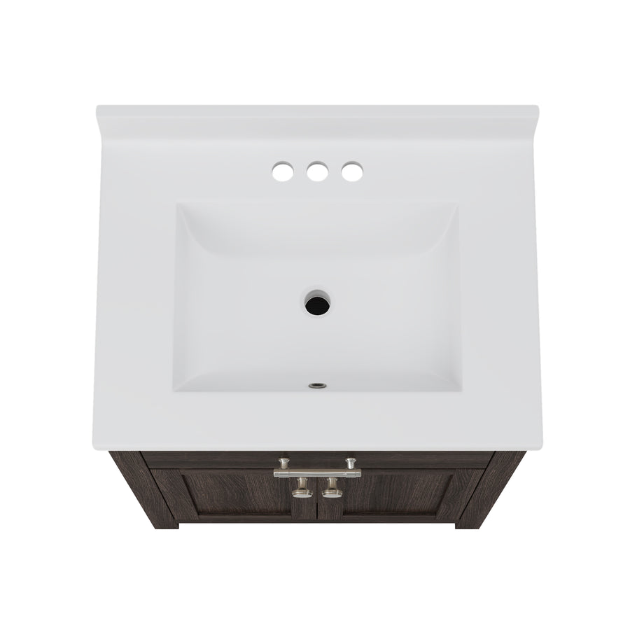Top-down view of a rectangular white bathroom sink with three faucet holes, set in a dark wood vanity with silver handles.