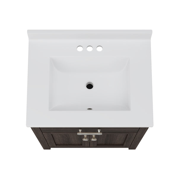 Top-down view of a rectangular white bathroom sink with three faucet holes, set in a dark wood vanity with silver handles.