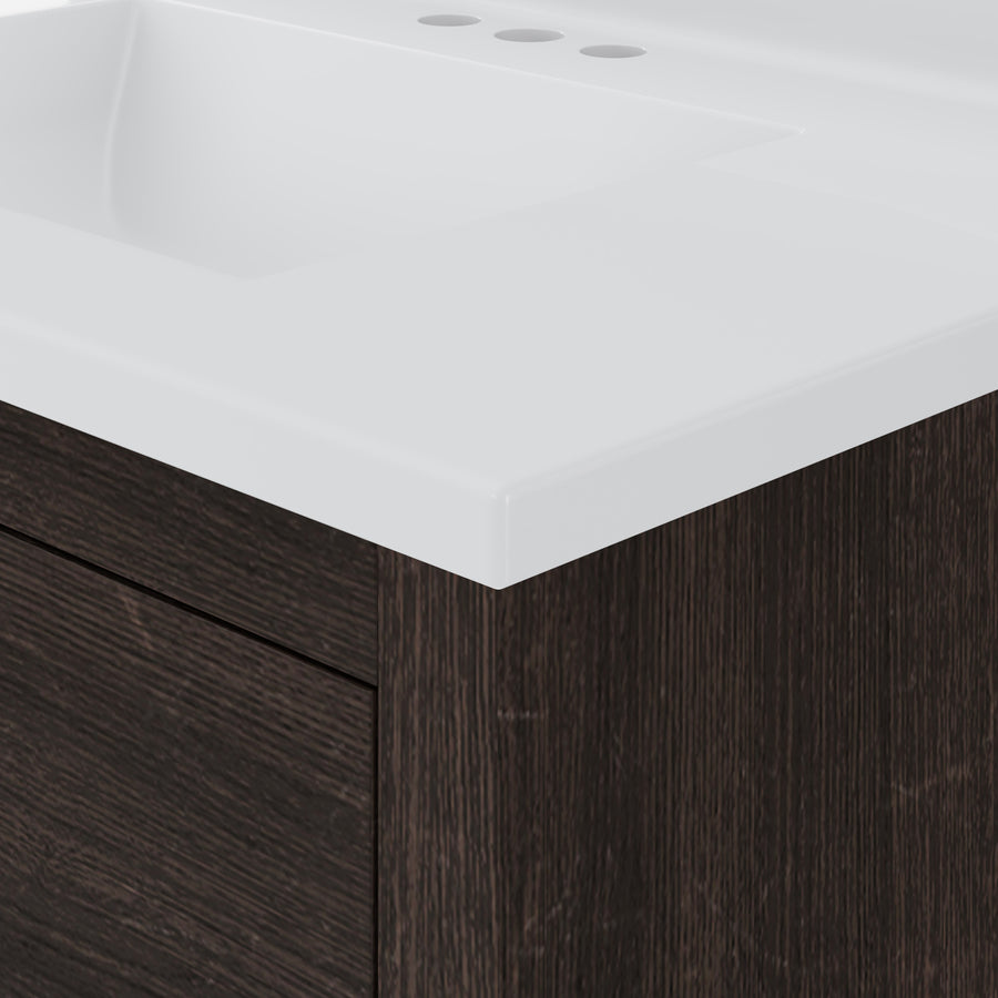 Close-up of a modern bathroom vanity with a white rectangular sink and a dark wood cabinet. The countertop has holes for faucet installation, and the design is sleek and minimalist.