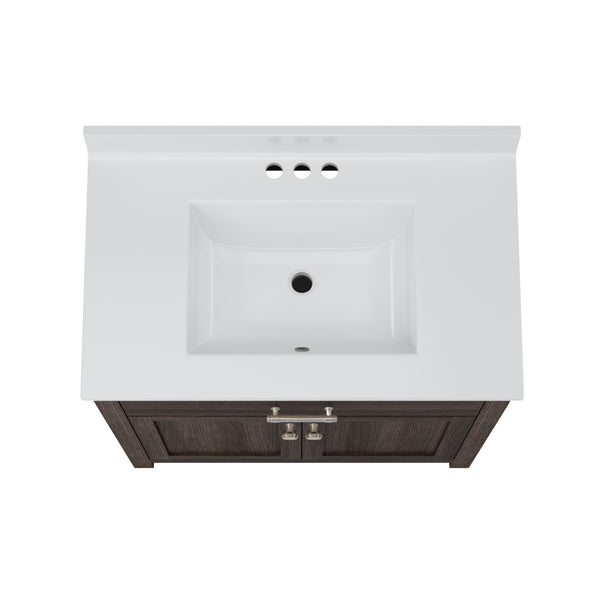 Top view of a rectangular white bathroom sink with three faucet holes, set in a white countertop above a dark wood vanity cabinet with two doors and silver handles.