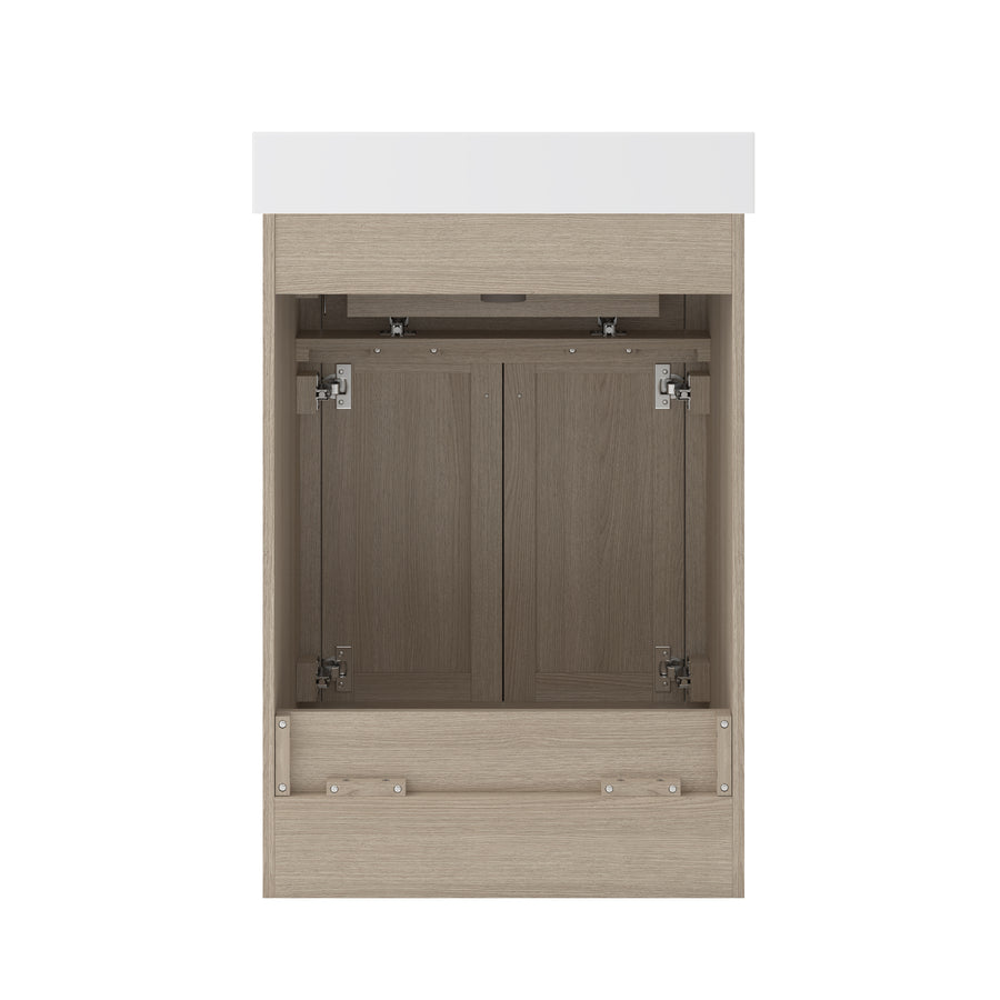 A light wood bathroom vanity with a white countertop, featuring double cabinet doors with metal hinges and no visible handles, shown open to reveal the interior.