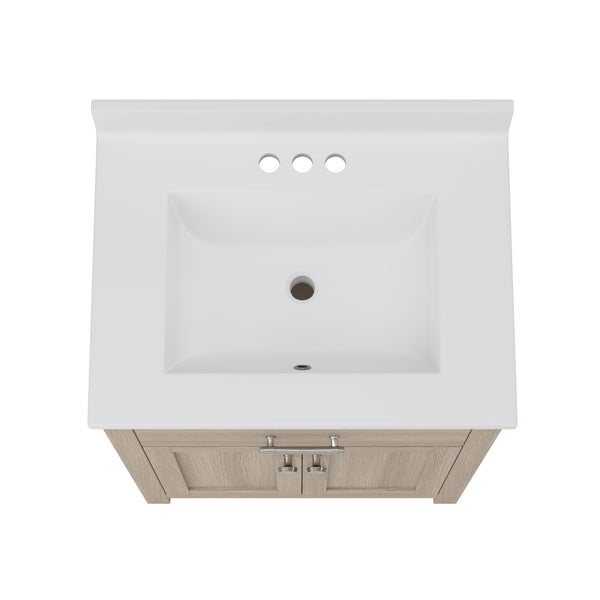 Overhead view of a white rectangular bathroom sink with three faucet holes, mounted on a light wood vanity cabinet with silver handles.