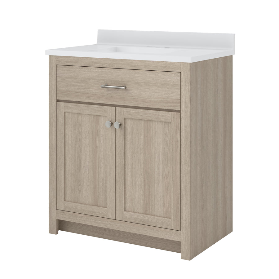 Light wood bathroom vanity with a white countertop, featuring one drawer with a silver handle and two cabinet doors with round silver knobs. The vanity has a simple, modern design.
